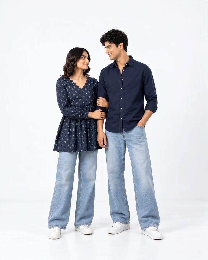 Midnight Indigo couple in coordinated navy tops and light denim, photographed together in a white studio